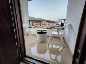 einen Balkon mit Blick auf einen Tisch und Stühle in der Unterkunft Prestigious Elegant Duplex - Abasscee in Freetown