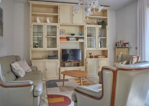 馬薩的住宿－Tuscan ART DECO Villa ~ Countryside Home，客厅配有椅子、电视和桌子