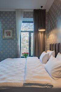 a large bed in a bedroom with a window at Hotel Day Inn in Tbilisi City
