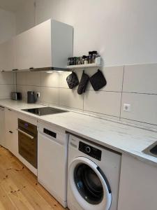a kitchen with a washing machine and a sink at Modern 2Room Apartment/Neukölln in Berlin