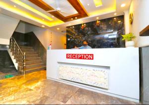 a reception desk in a building with a person in the background at Pacefic Suites The Hotel Near Delhi international airport in New Delhi