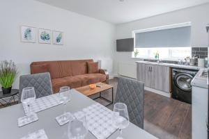 cocina y sala de estar con mesa y sillas en Modern family home w/Wi-Fi, Netflix, self check-in, en Londres