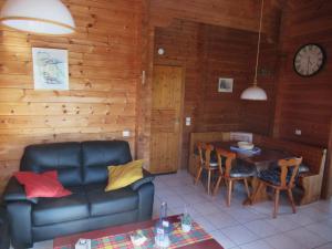 a living room with a couch and a table at Le chalet Roy in Mauroux