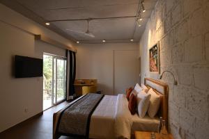 a hotel room with a bed and a television at Bedzzz Xclusiv Morjim, Goa By Leisure Hotels in Morjim