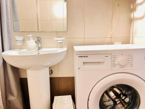 La salle de bains est pourvue d'un lave-linge et d'un lavabo. dans l'établissement Elvita Apartments 2, à Athènes