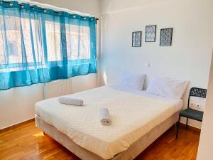 アテネにあるElvita Apartments 2のベッドルーム1室(青いカーテン付きの大型ベッド1台付)
