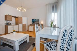 eine Küche und ein Esszimmer mit einem weißen Tisch und Stühlen in der Unterkunft Villa Seeland Villa Seeland App 5 in Heringsdorf