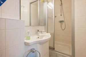 ein weißes Bad mit einem Waschbecken und einer Dusche in der Unterkunft Villa Seeland Villa Seeland App 5 in Heringsdorf