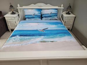 Una cama con el océano y una gaviota en De ZeeuwSter, en Burgh Haamstede