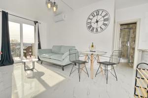 a living room with a couch and a clock on the wall at KM Apartments in Kotor