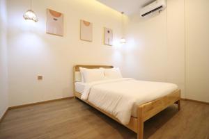 a bedroom with a bed with white sheets and pillows at Casabella 103 A2 Grand Batam Penuin Wet Market in Nagoya