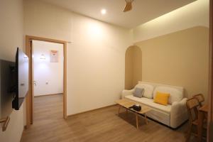 ナゴヤにあるCasabella Homestay 103 Batam Penuinの白いソファとテーブルのあるリビングルーム +14枚の写真