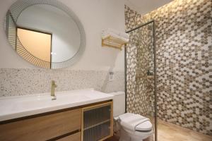 ナゴヤにあるCasabella Homestay 103 Batam Penuinの洗面台、鏡、トイレ付きのバスルーム