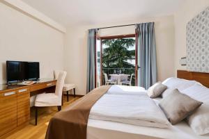 a bedroom with a bed and a desk and a television at Villa Dobravac Wine Estate in Rovinj