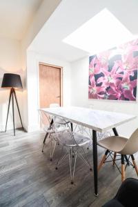 una mesa y sillas en una habitación con una pintura en Urban Oasis, en Londres