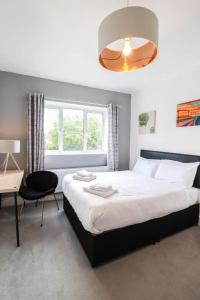 1 dormitorio con cama, escritorio y ventana en Urban Oasis, en Londres