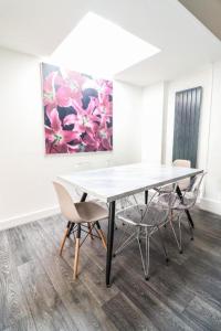 a table and chairs in a room with a painting at Urban Oasis in London