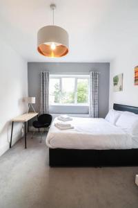 1 dormitorio con cama, escritorio y ventana en Urban Oasis, en Londres