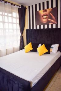 Una cama con almohadas amarillas y negras. en Kahawa sukari luxury home, en Nairobi