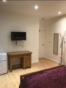 1 dormitorio con escritorio y TV en la pared en Cambridge City Mill en Cambridge