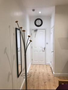 a hallway with a clock on the wall next to a door at Cambridge City Mill in Cambridge