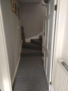 a hallway with a stairway with a stair case at Cheerful 3-bedroom townhouse with free parking on site in Taunton