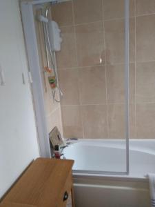 a bathroom with a white tub and a shower at Cheerful 3-bedroom townhouse with free parking on site in Taunton