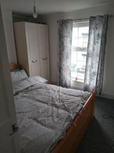 - une chambre avec un lit et une fenêtre avec des rideaux dans l'établissement Cheerful 3-bedroom townhouse with free parking on site, à Taunton