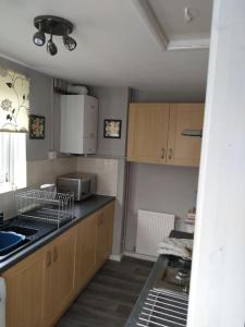 a kitchen with a sink and a counter top at Cheerful 3-bedroom townhouse with free parking on site in Taunton