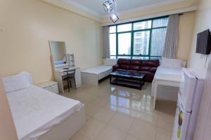 a hotel room with two beds and a couch at MC Budget Rooms for Girls Apartment Number 4202 in Dubai