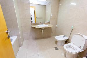 a bathroom with a toilet and a sink and a mirror at MC Budget Rooms for Girls Apartment Number 4202 in Dubai