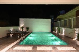 a swimming pool at night on a building at Bedzzz Xclusiv Morjim, Goa By Leisure Hotels in Morjim