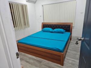 a bedroom with a bed with blue sheets and blue pillows at Moutain View Villa in Pacific Harbour