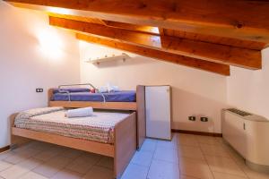 sypialnia z 2 łóżkami piętrowymi i lodówką w obiekcie VistaLago Green Residence 100m From Lake - Happy Rentals w mieście Desenzano del Garda