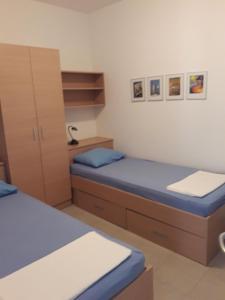 Cette chambre comprend 2 lits et une armoire. dans l'établissement Apartments Paska Preko, à Preko
