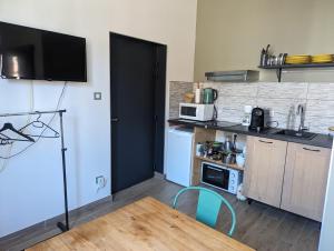 a small kitchen with a table and a microwave at Moustier in Montauban