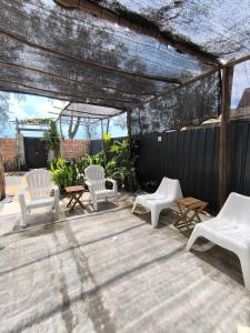 un gruppo di sedie e tavoli bianchi su un patio di Tamu Beradu Seaview Private Villa CoLiving a Dungun