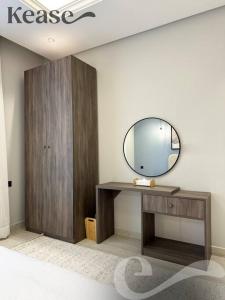 a dressing table with a mirror and a wooden cabinet at Kease Malqa D-12 Royal Touch GZ20 in Riyadh
