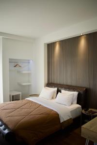 1 dormitorio con 1 cama grande con almohadas blancas en Minoa Athens Hotel en Atenas
