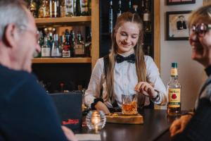 a woman sitting at a bar with a drink at Der Rindererhof in Tux