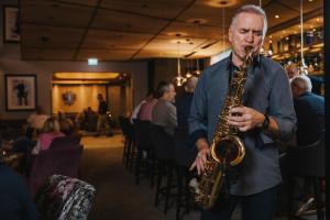 a man playing a saxophone in a restaurant at Der Rindererhof in Tux