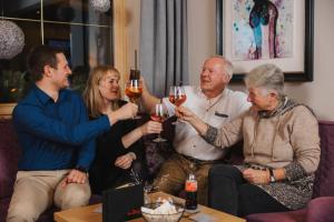 a group of people sitting on a couch drinking wine at Der Rindererhof in Tux