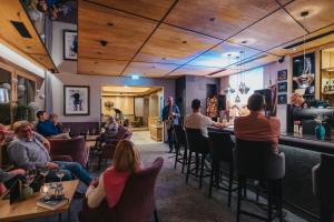 a group of people sitting at a bar in a restaurant at Der Rindererhof in Tux