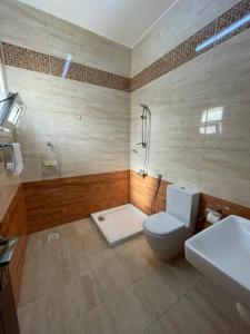 a bathroom with a shower and a toilet and a sink at للإيجار استوديوهات ضمن فيلا جديده كلياً in Al Khawḑ