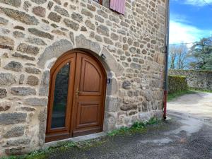 a wooden door on the side of a stone building at Studio ardéchois in Quintenas