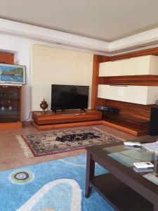 een woonkamer met een flatscreen-tv en een salontafel bij VillaSun Kleopatra in Alanya
