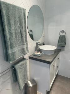 a white bathroom with a sink and a mirror at Happy Valley Rest in Port Lincoln