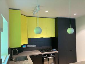 a kitchen with green and yellow cabinets and a stove at Bijou Mews in the Victorian Q in Cork
