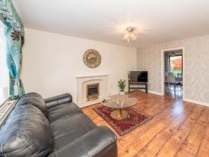 a living room with a leather couch and a table at Spacious Home with Modern Amenities Near IKEA Pass the Keys in Reading