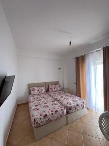 1 dormitorio con 1 cama y TV en Evita's House, en Lukovë